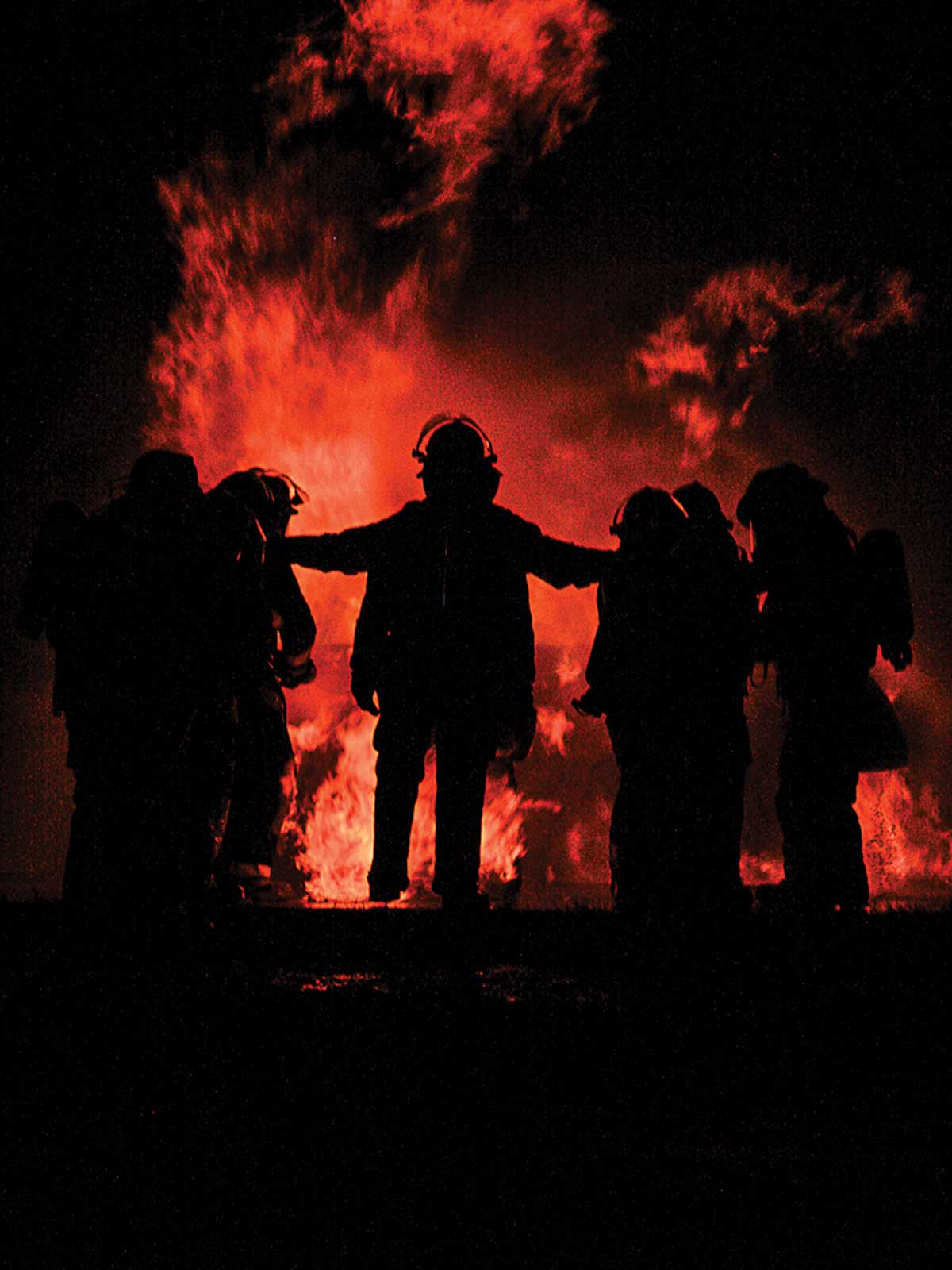 photo of firefighters silhouetted against a fire