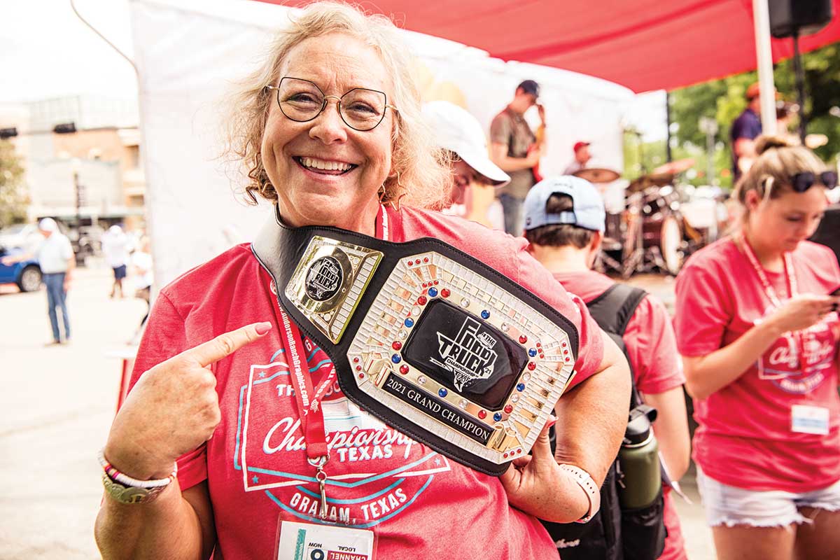 volunteer holds up grand champion belt