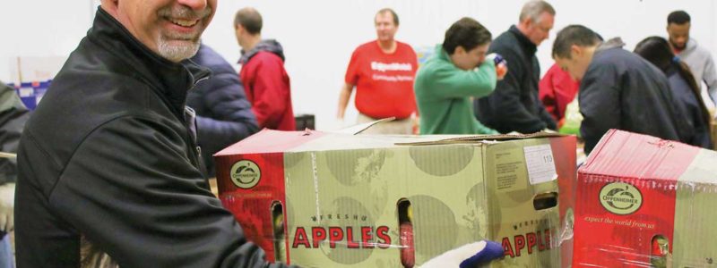 man loads boxes of apples