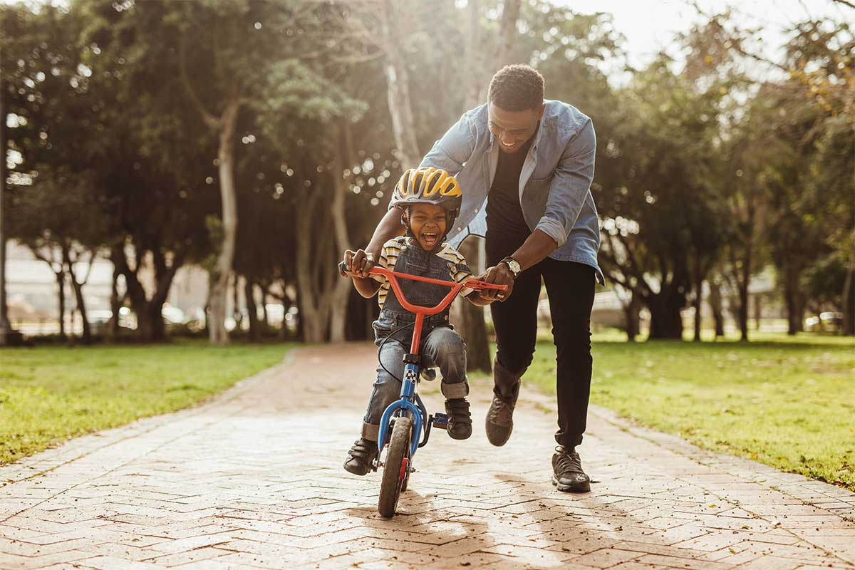 Father helps son learn to ride a bike