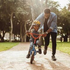 Father helps son learn to ride a bike