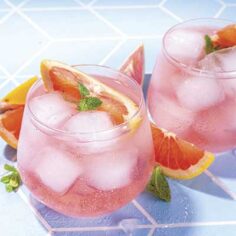 summery pink drinks over ice with grapefruit slices