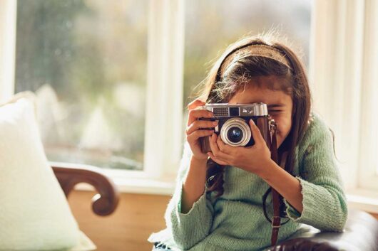A young girl shooting with a vintage camera