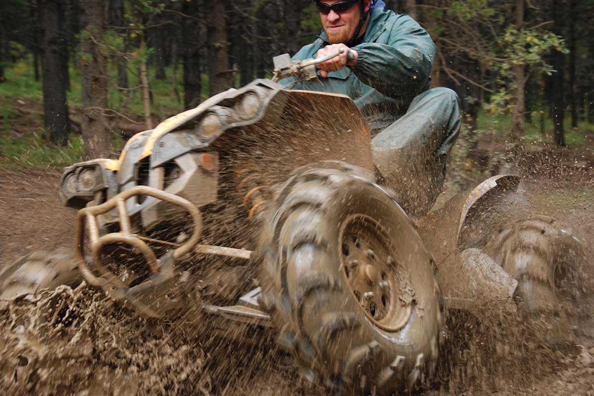 Man splashing through mud on an ATV