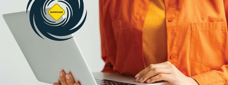 Woman holding laptop with hurricane symbol