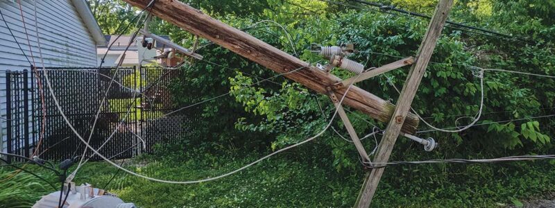 Downed power pole next to a homeSanya Kushak | iStock.com