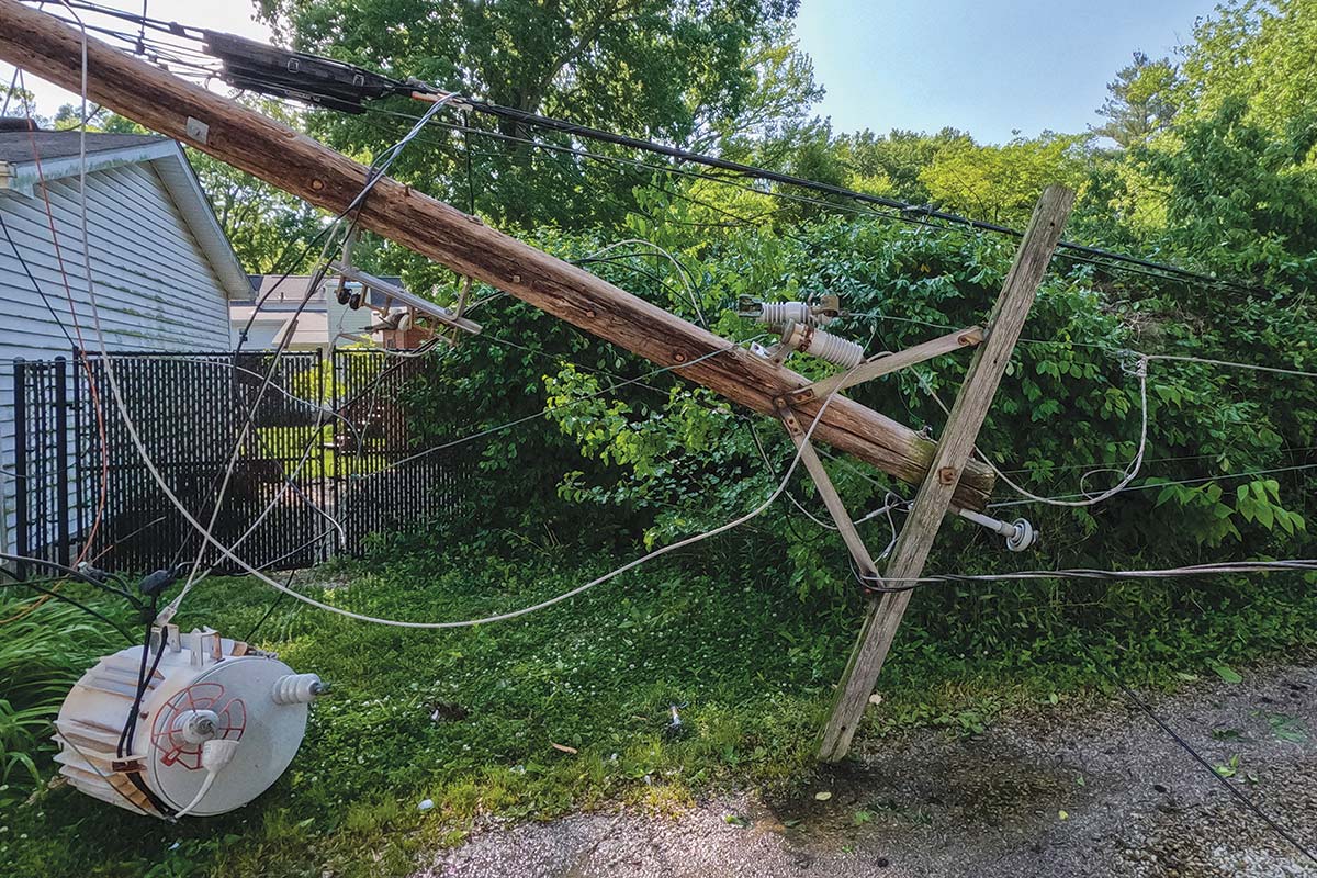 Downed power pole next to a homeSanya Kushak | iStock.com