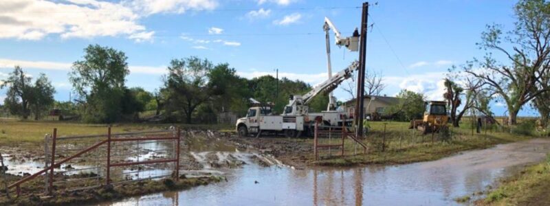 workers use bucket truck to work on lines after a storm