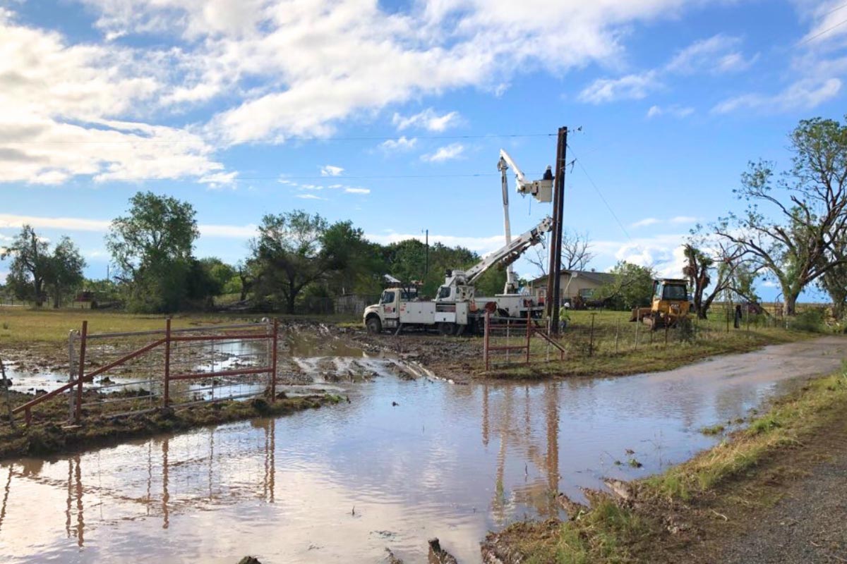 workers use bucket truck to work on lines after a storm